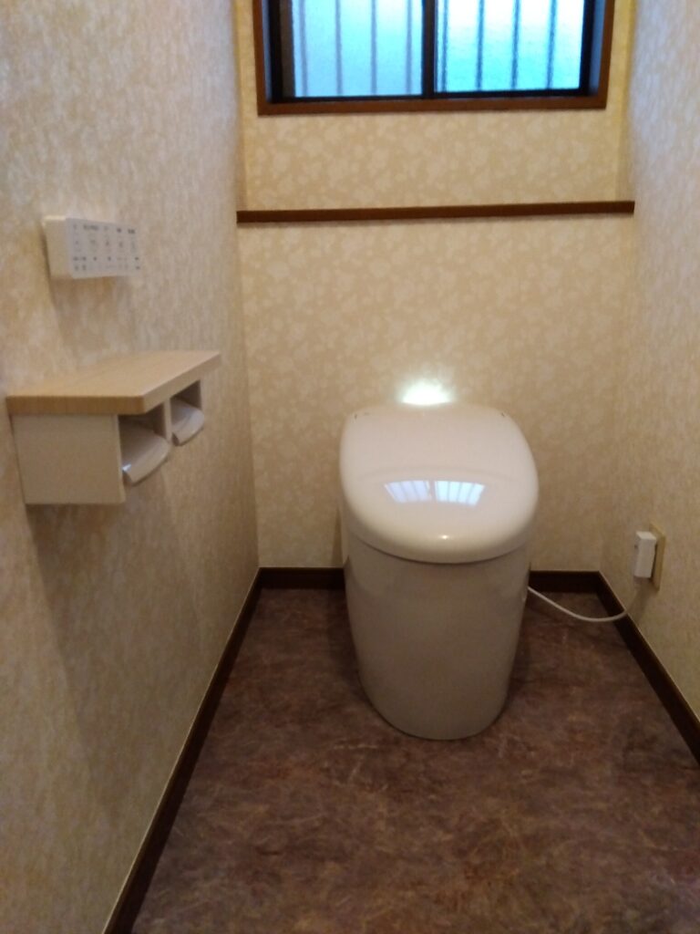 トイレ全体が明るくなりました。タンクレストイレで空間が広がり、節水で機能的にも良くなりました。本体奥側からの柔らかな光が空間を照らします。暖色系のクロス、クッションフロアーをお選びになり温かみのあるトイレに一新されました。