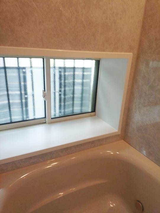 浴室外窓交換の様子です。窓枠が白くまわりとも馴染み明るい雰囲気に。面格子付きなので防犯性にも優れています。